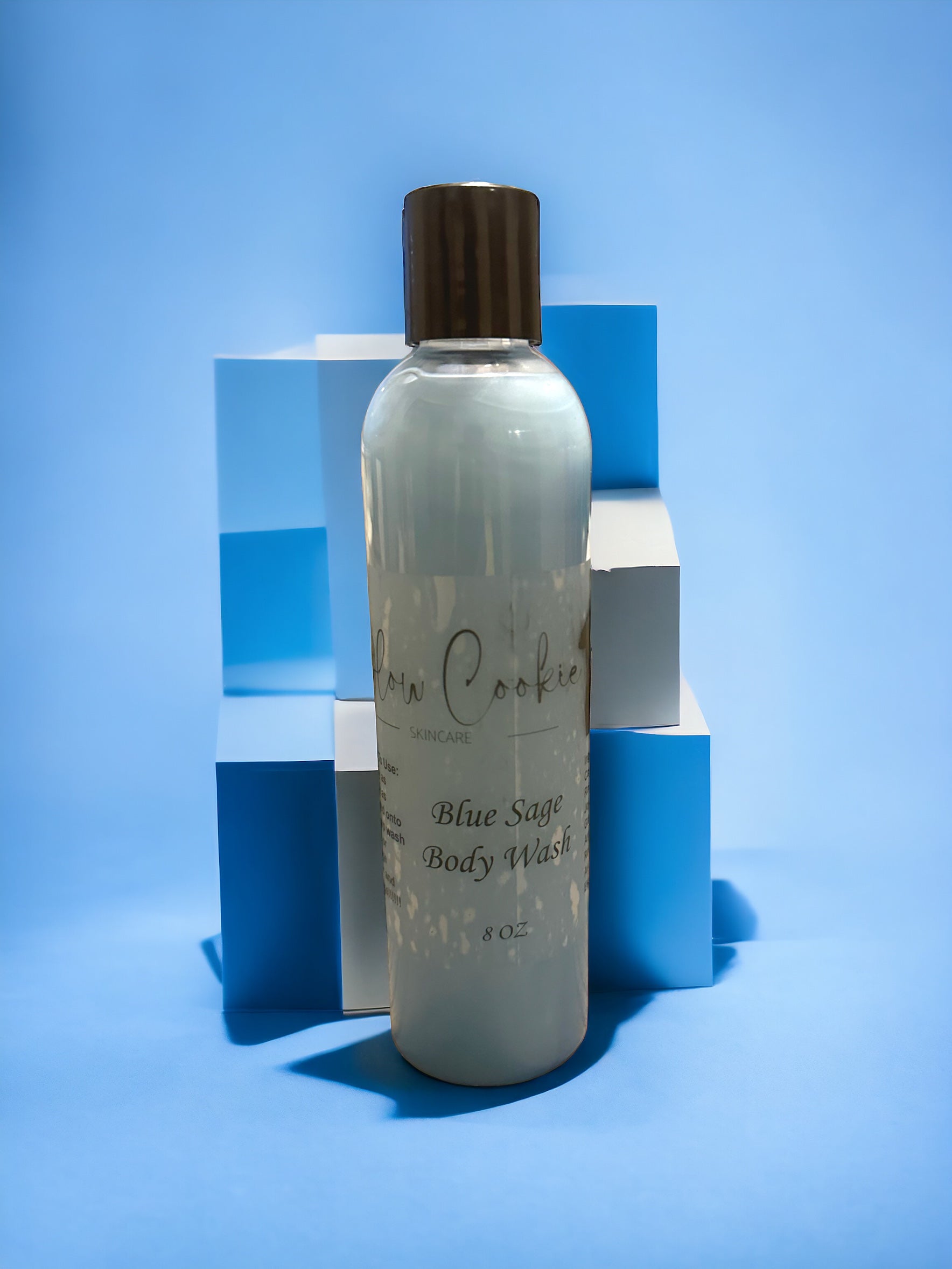 An image of a sleek blue bottle of men's body wash, standing in front of stacked blue and white blocks, creating a modern and dynamic composition.